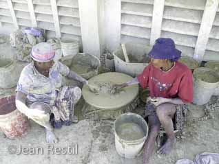 Two Haitian women sifting the clay for t&eacute;